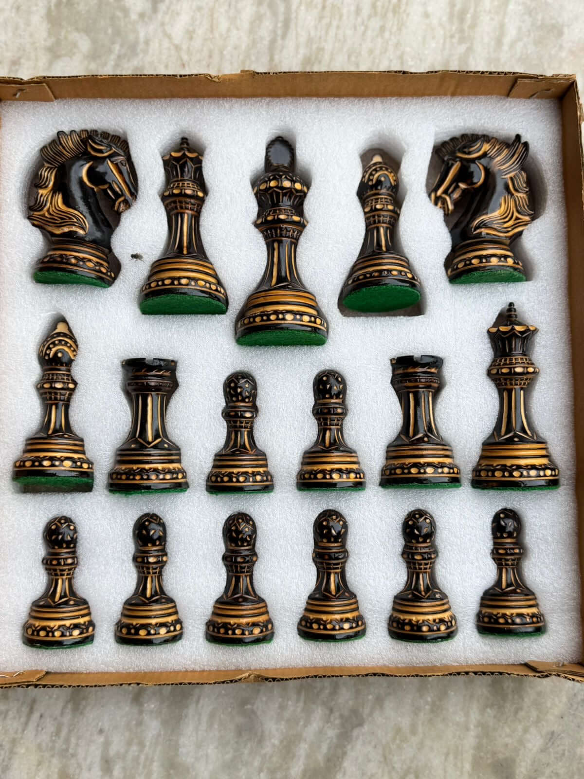 Alexandria Luxury Staunton Burnt Chess Pieces Set arranged in a box, featuring hand-carved detailed black and gold pieces.