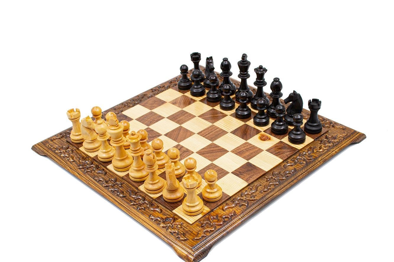 Hand carved wooden chess set with unique Staunton pieces on ornate foldable chess board.