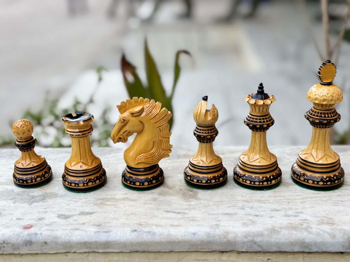 Display of Alexandria Luxury Staunton burnout chess pieces, including knight, rook, queen, and more, in elegant boxwood.