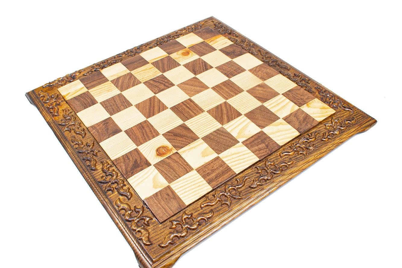 Hand carved wooden chess board with decorative edges, featuring a classic checker pattern in light and dark wood.