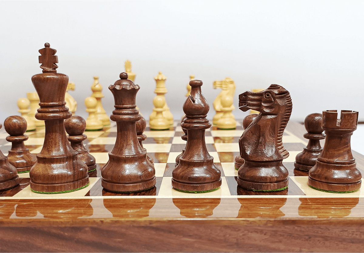 Handcrafted wooden Staunton chess pieces on a luxury chess board in rich dark wood.