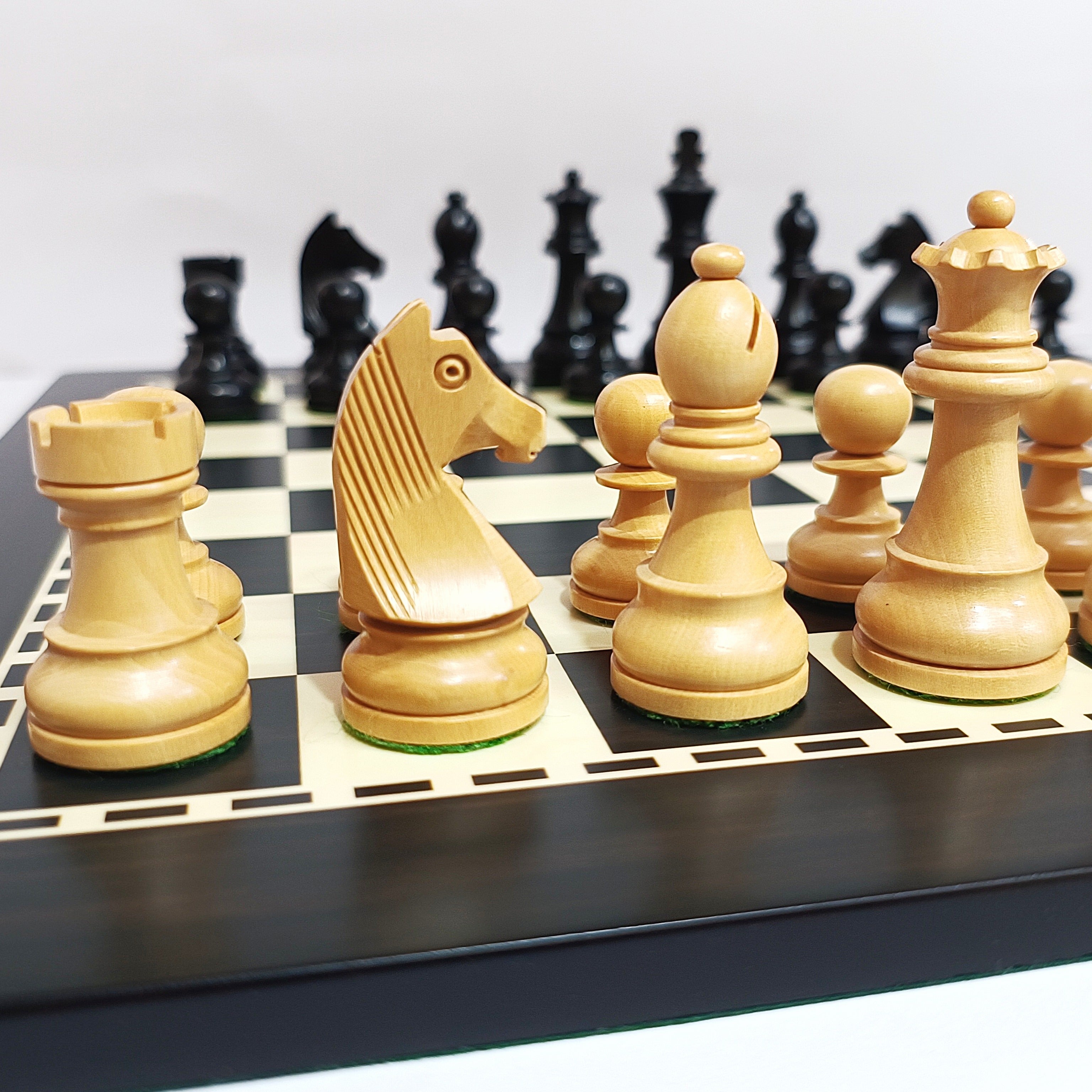 Classic Staunton wooden chess pieces on a black and white MDF chess board, showcasing ebonized and natural boxwood details.