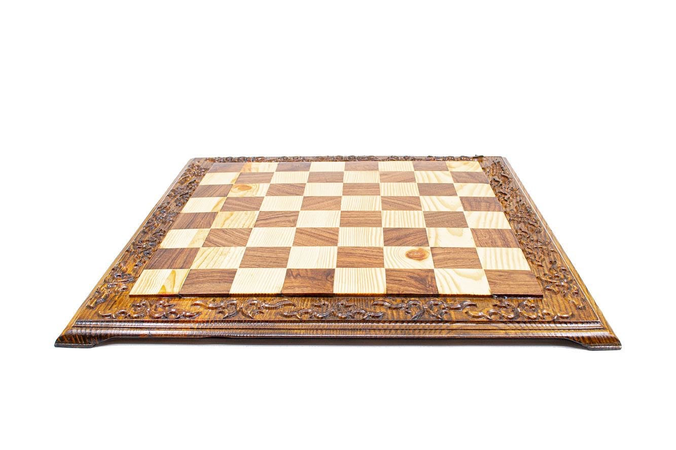 Hand engraved wooden chess board with a decorative carved border and a classic 8x8 checkered pattern.