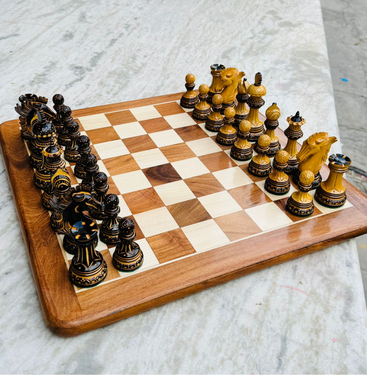 Alexandria Luxury Staunton chess pieces set in boxwood on wooden chess board, featuring hand-carved intricate designs and detailed knights.