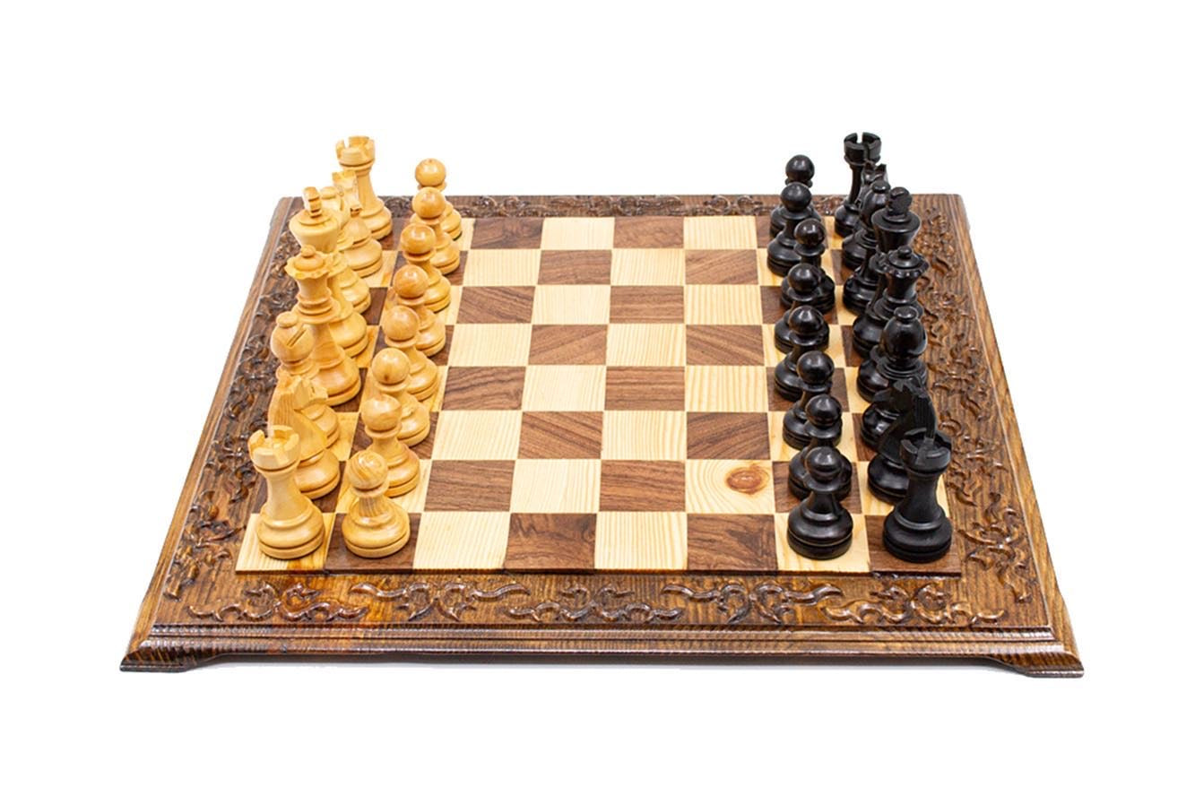 Hand carved wooden chess set featuring light and dark Staunton chess pieces on an engraved foldable board.