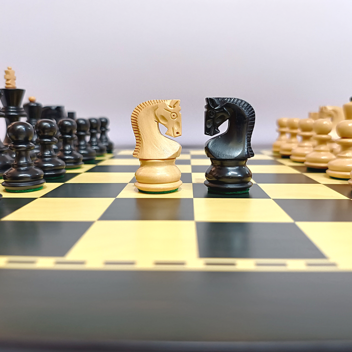Black and cream chess pieces on a wooden board, featuring knight pieces in focus during a game.