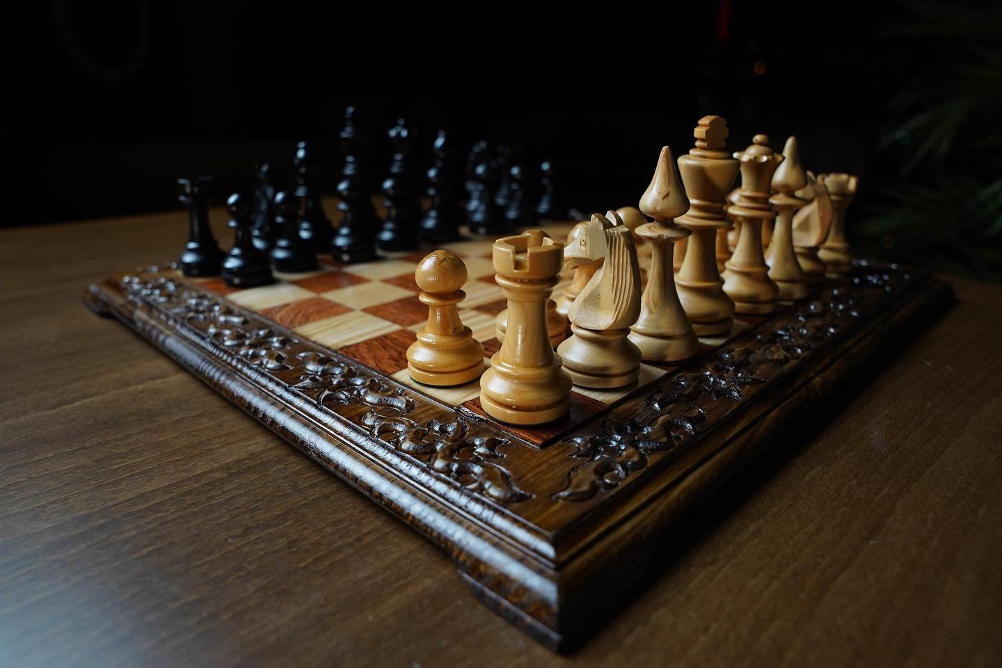 Hand carved wooden chess set featuring unique Staunton pieces on a foldable engraved chess board.