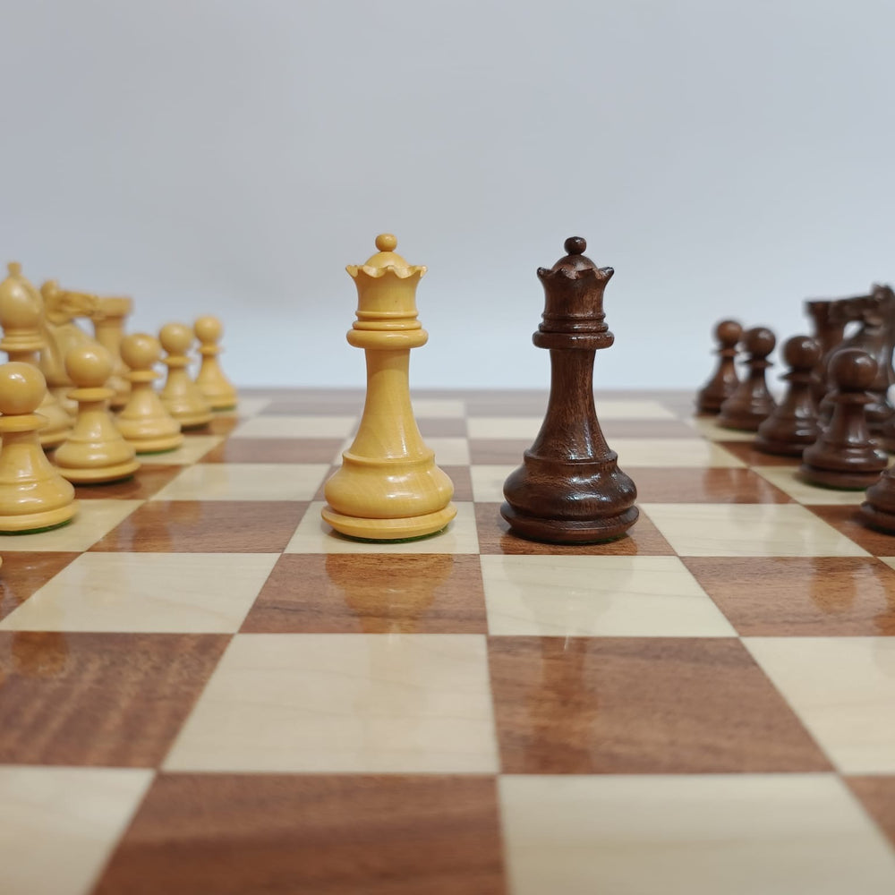 Close-up of Supreme / Fierce Knight Staunton chess pieces on a wooden chess board, featuring two queens in acacia wood.