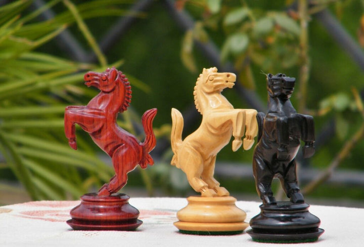 Luxury chess knight pieces in red, beige, and black, showcasing intricate craftsmanship and modern design.