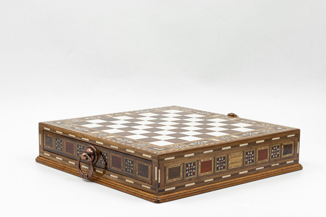 A decorative wooden chess board with intricate designs, featuring a checkered pattern and a locking mechanism.