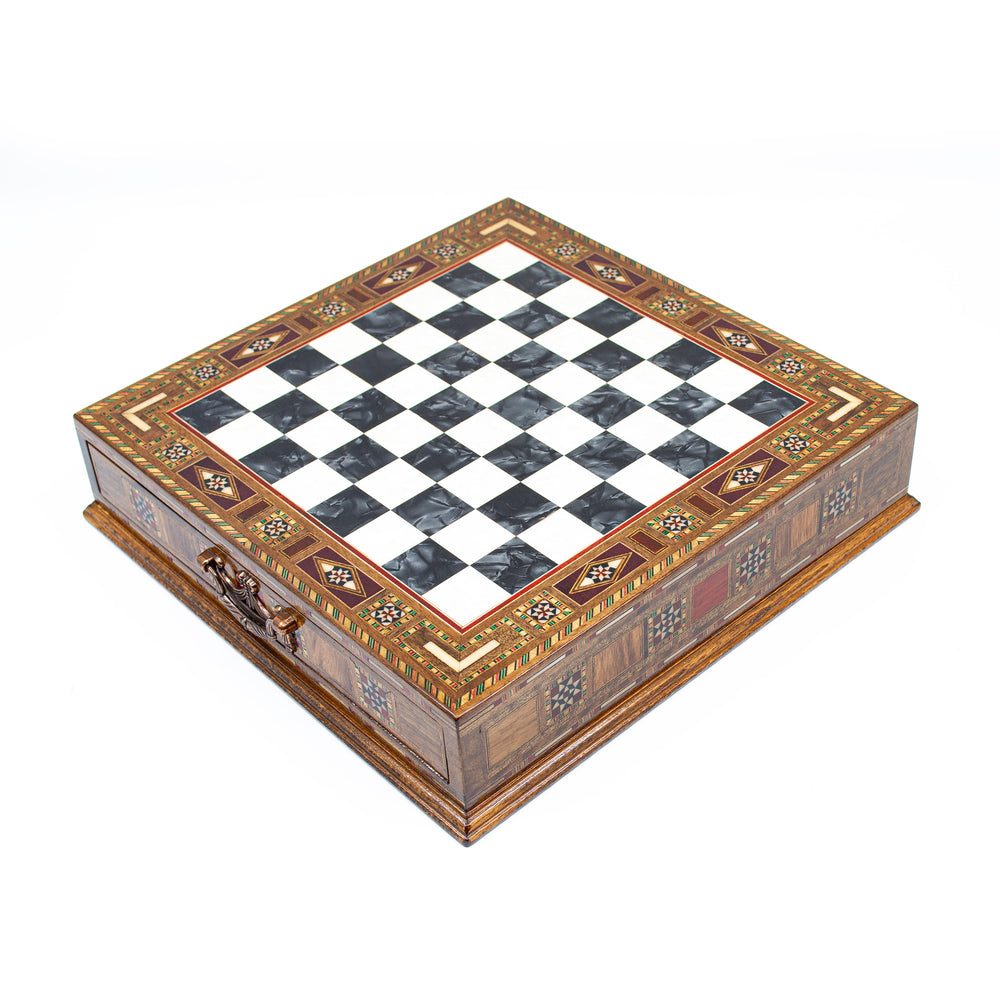 Elegant wooden chess board with a black and white checkered pattern and intricate decorative edges.