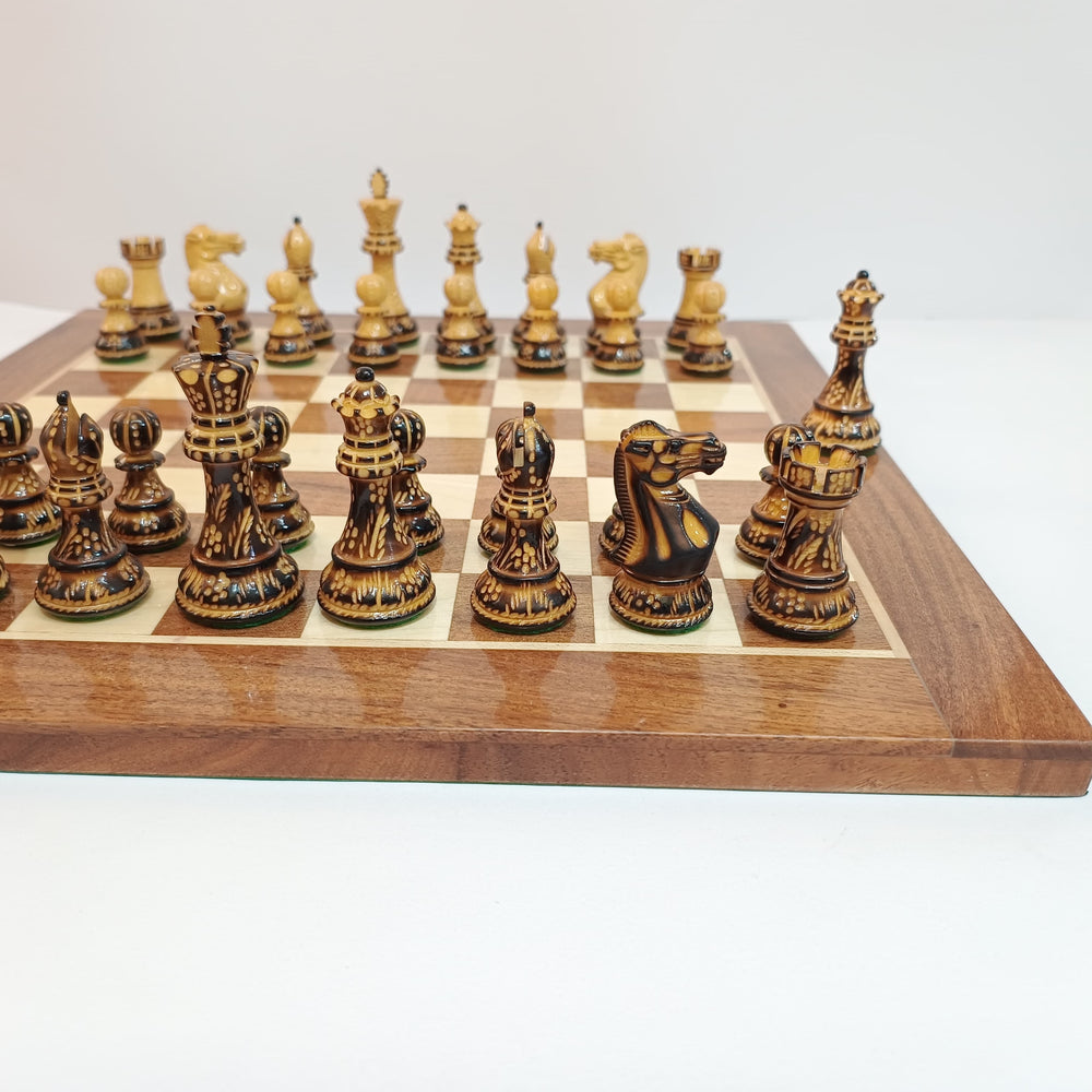 Hand carved burnt Staunton chess pieces on a professional acacia chess board.