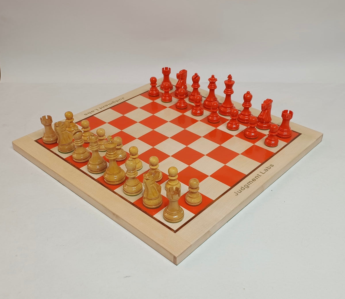 Custom orange and natural wood chess set made for Judgment Labs with engraved company name