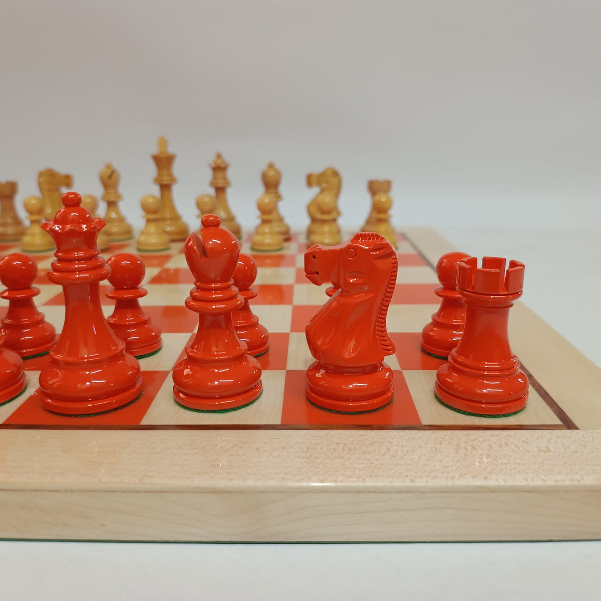 Close-up of the custom orange Judgment Labs chess pieces and company name engraved into the wooden board